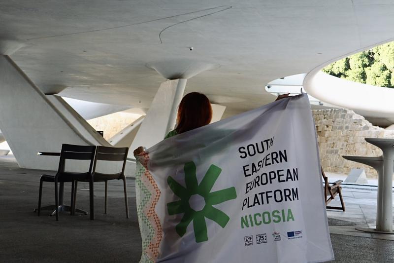 A girl holding the South Eastern European Platform Nicosia flag