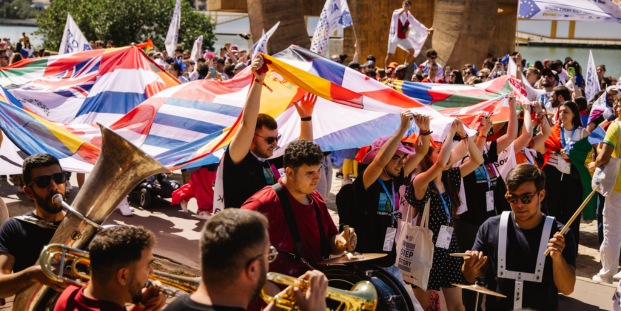 A big group of people in a parade with country flags.