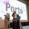 A picture of people hugging on a stage and a screen showing the word "Porto".