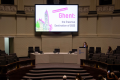 A person having a presentation about Erasmus Destination of the Year 2023 (Ghent, Belgium) in a round room.