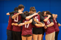 A picture of a volleyball team hugging.